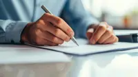 Closeup on hands signing a document